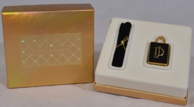 Compacts - Perfume Holder. Estee Lauder solid perfume compact in the shape of a handbag made exclusively for David Jones presented in a hat box.